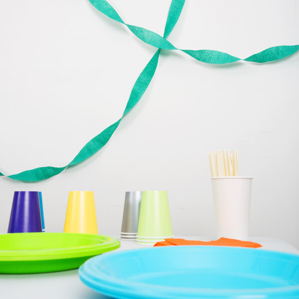 A table with emerald green streamer paper and plates.