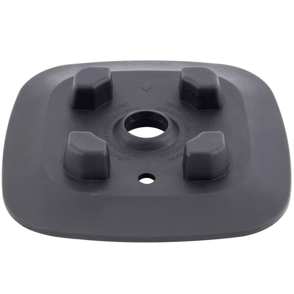 A black plastic square with four holes.