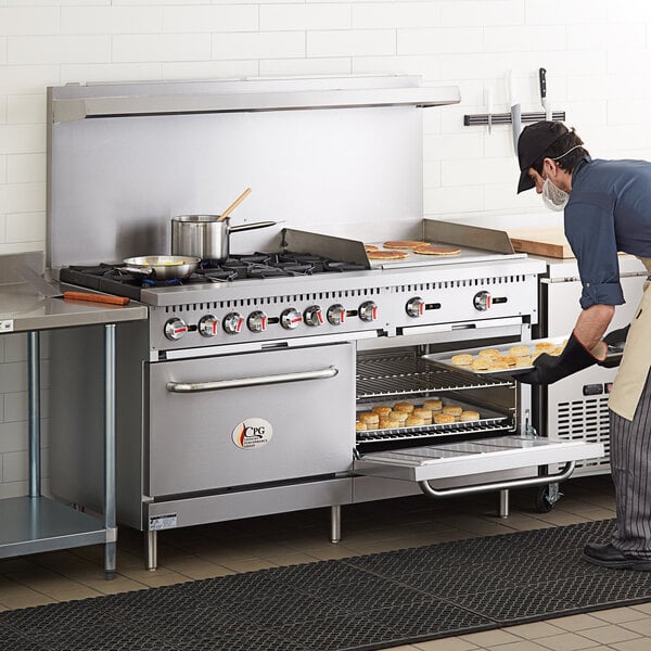 A man using a Cooking Performance Group 60" range with 2 ovens and a griddle to cook food.