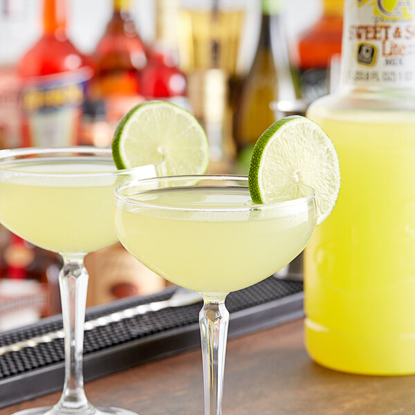 Two glasses of Finest Call Lite Sweet and Sour Mix with lime slices on the rim.