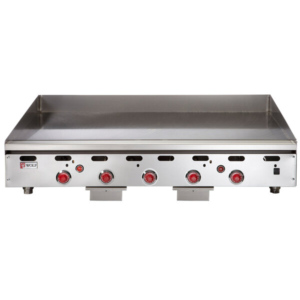 A Wolf stainless steel countertop griddle with red knobs.