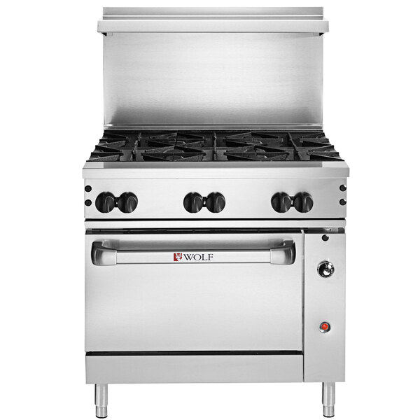 A Wolf Challenger XL series stainless steel range with 6 burners and black knobs on a counter in a professional kitchen.