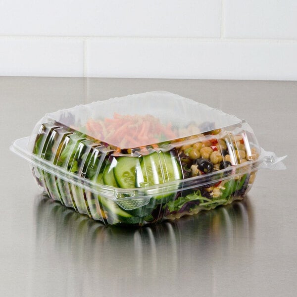 A Dart ClearSeal plastic container with salad and vegetables inside.