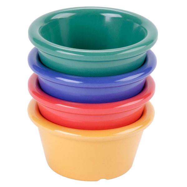 A stack of colorful plastic GET Diamond Mardi Gras ramekins with a blue bowl on top.