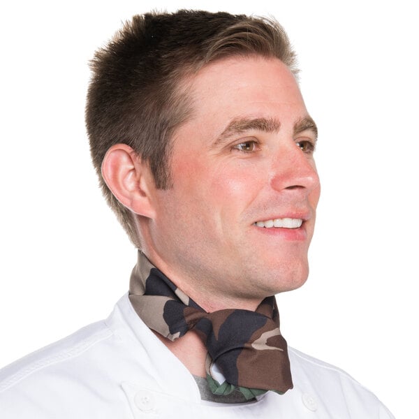A man in a chef's uniform wearing a camouflage chef neckerchief.