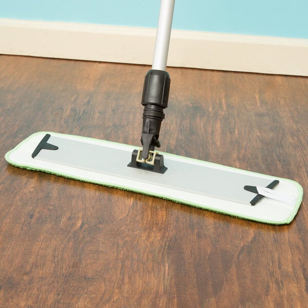 A Lavex microfiber mop with a green handle on a wood floor.
