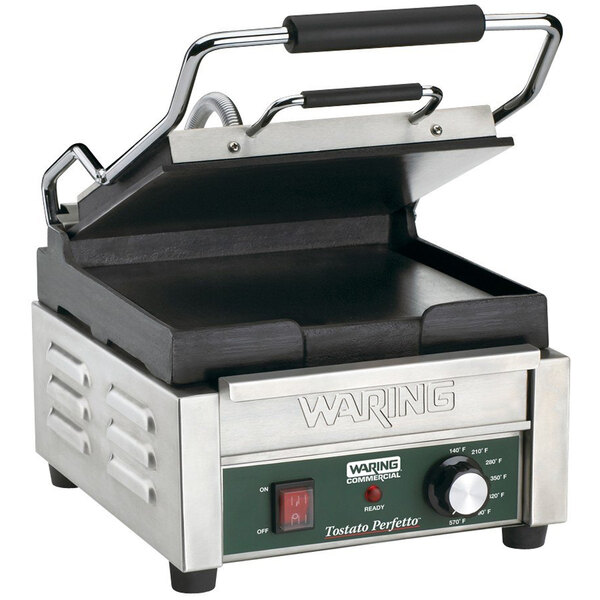 A close-up of a Waring Tostato Perfetto Panini Grill on a table in a farm-to-table restaurant.