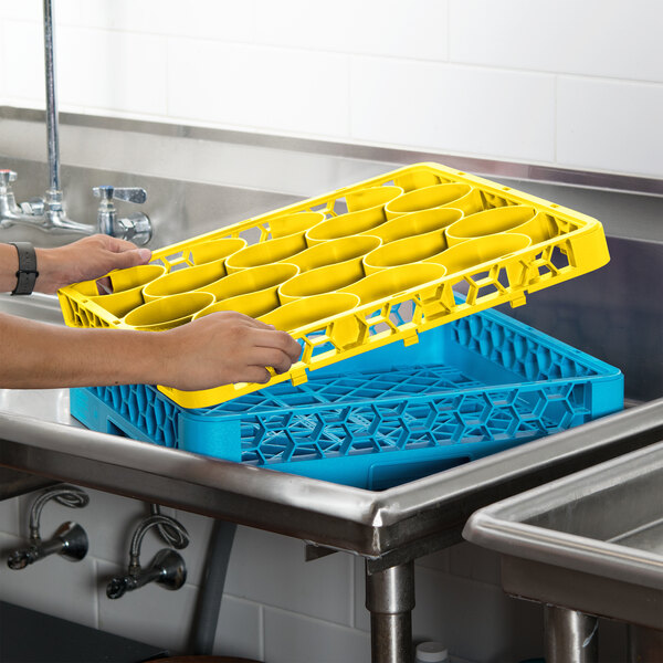 A person holding a yellow Carlisle glass rack extender.