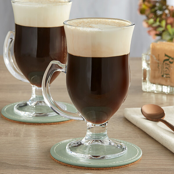 A table with two Acopa Irish Coffee Mugs filled with brown liquid.
