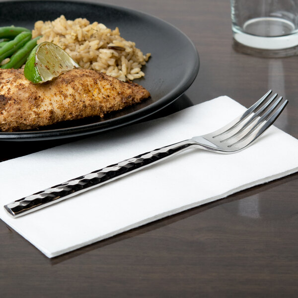 A plate of food with chicken, rice, and green beans next to a 10 Strawberry Street heavy weight stainless steel dinner fork.