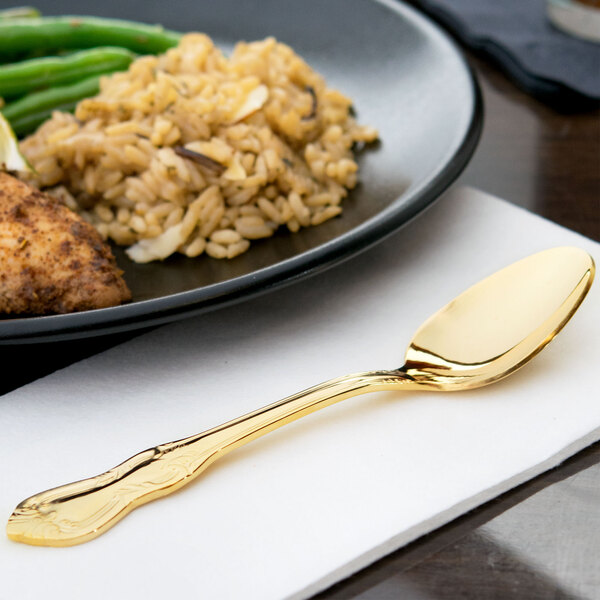 A plate of food with a Crown Royal gold plated stainless steel teaspoon on it.