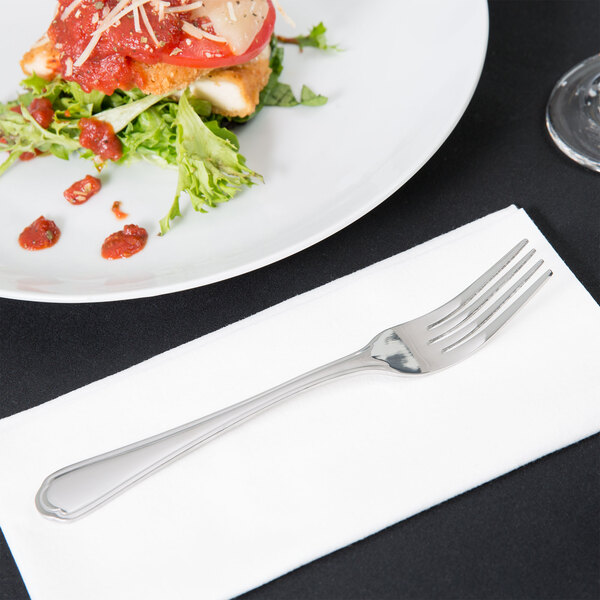 A 10 Strawberry Street stainless steel dinner fork on a plate with food.