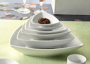 A CAC Super White triangular porcelain bowl filled with chocolate on a table in a sushi bar.