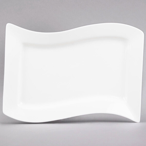 A CAC Miami bone white rectangular porcelain platter with a curved edge.