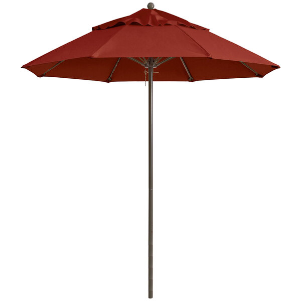A close-up of a red Grosfillex Windmaster umbrella on a metal pole.