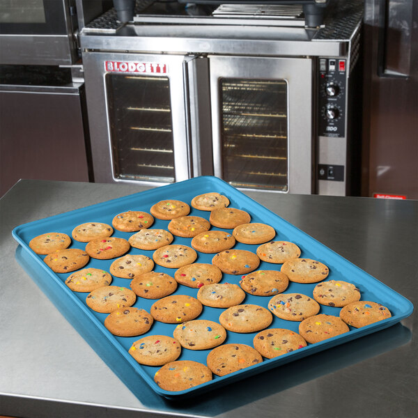 A Sky blue MFG Tray supreme display tray of cookies on a kitchen counter.
