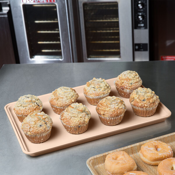 A MFG Tray bakery display tray of muffins on a counter.