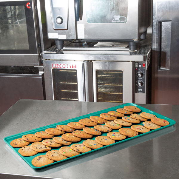 A Mint Green MFG Tray of cookies on a counter.