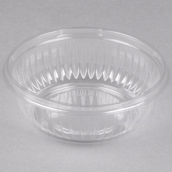A Dart clear plastic bowl with a curved edge on a white background.
