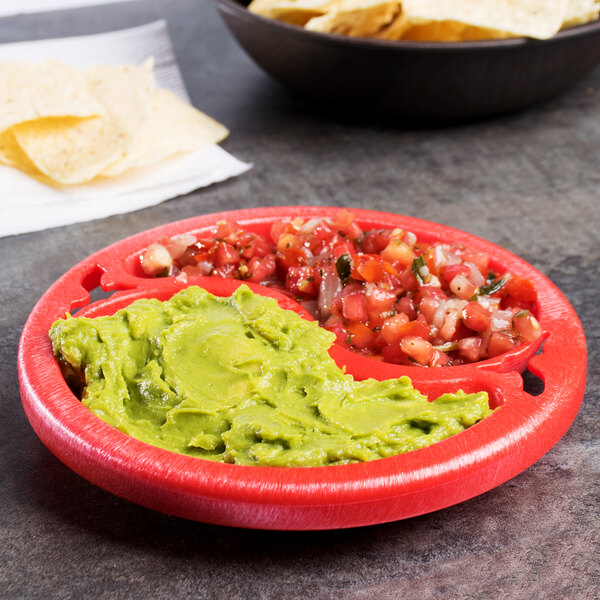 A close up of a red HS Inc. Chile Doble divided plastic bowl with guacamole and chips.