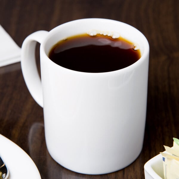A white Libbey porcelain mug filled with coffee on a table.
