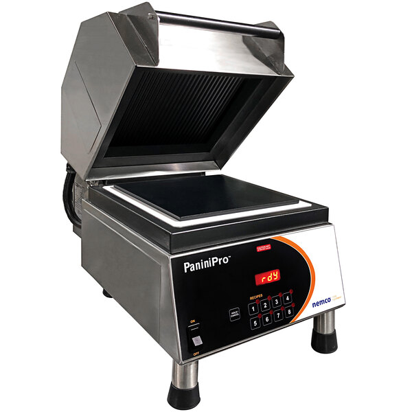A Nemco PaniniPro single panini press with grooved and flat plates on a counter in a professional kitchen.