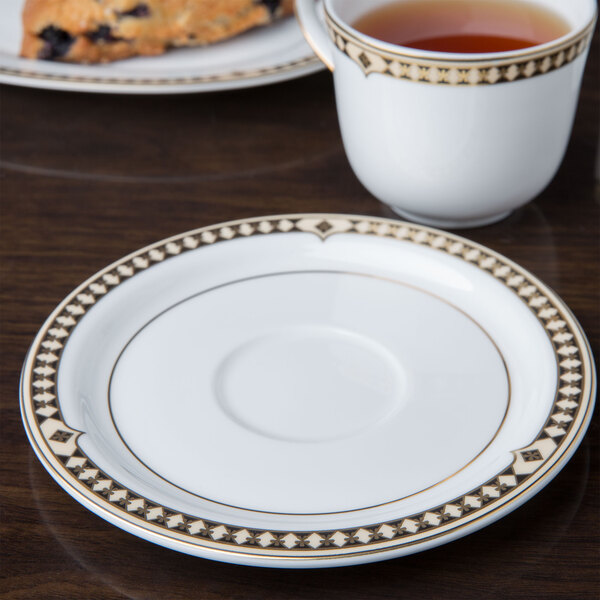 A Syracuse Baroque bone china saucer with a cup of tea on it.