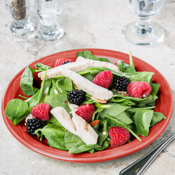 A Libbey Cayenne carved porcelain round plate with a salad of chicken, berries, and spinach.