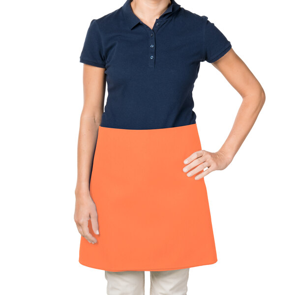 A woman wearing an orange Intedge waist apron.