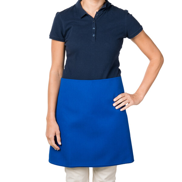 A woman wearing an Intedge blue poly-cotton waist apron.