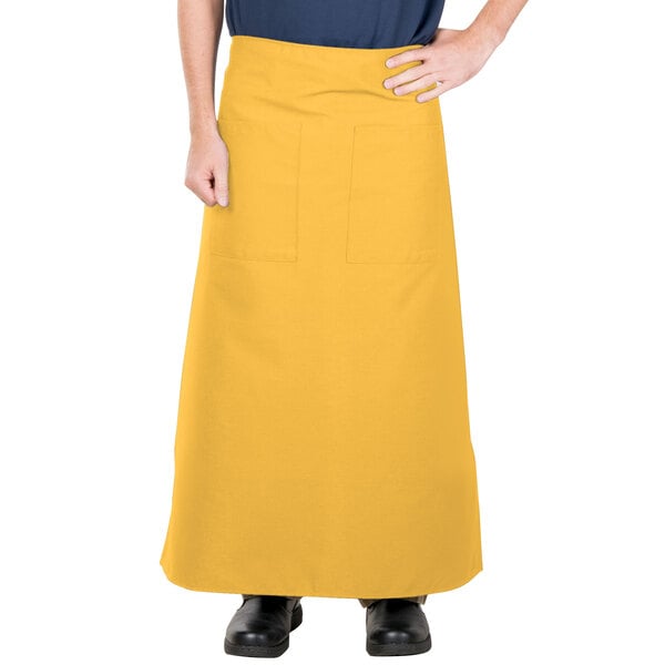 A person wearing a yellow Intedge bistro apron.