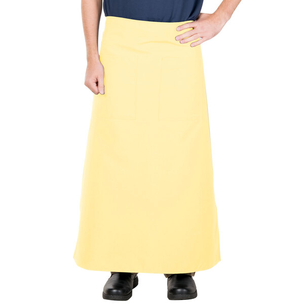A person wearing a yellow Intedge bistro apron with 2 pockets.