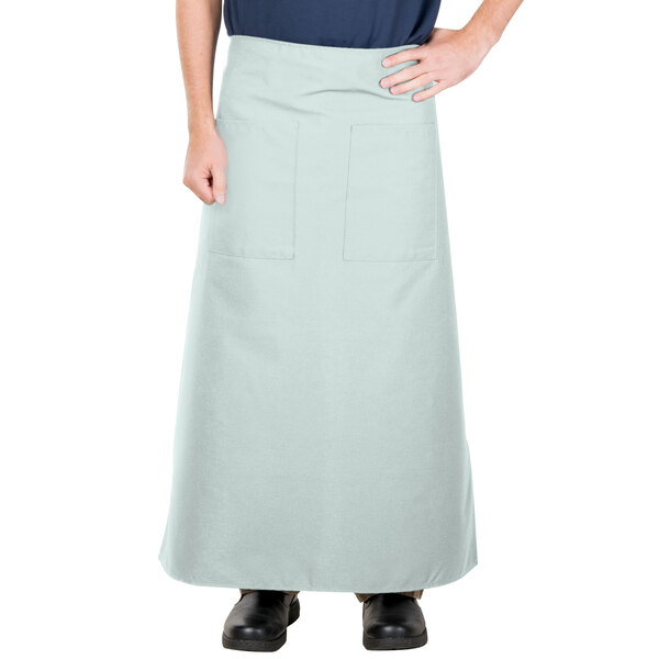 A man wearing a sea green Intedge bistro apron with 2 pockets.