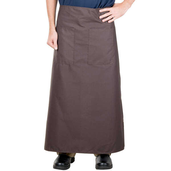 A man wearing a brown Intedge bistro apron with 2 pockets.