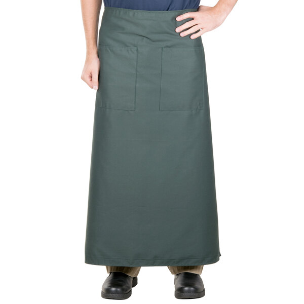A man wearing a hunter green Intedge bistro apron with pockets.