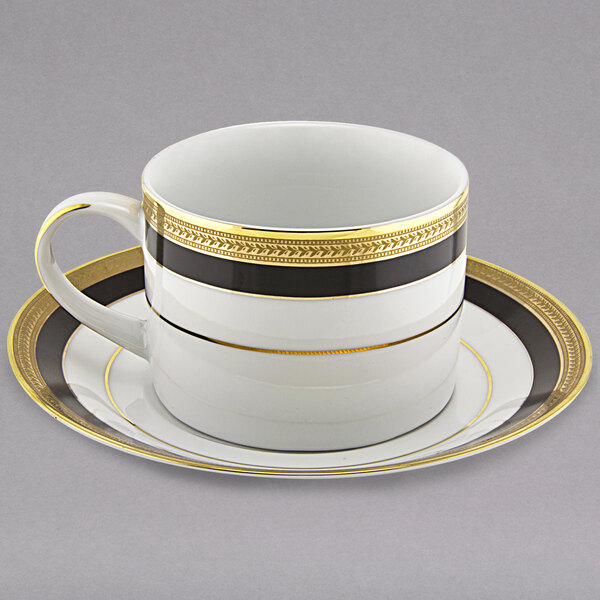 A white and gold porcelain can cup and saucer with a gold rim.