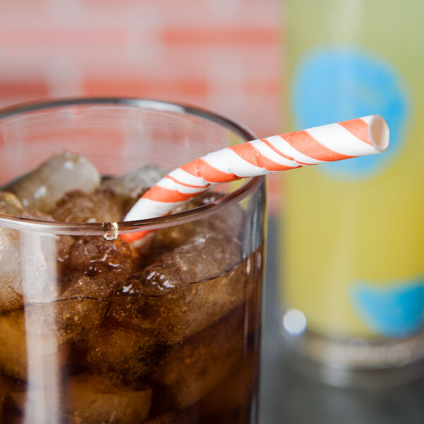 A glass of iced tea with a Sunkissed Orange and white striped paper straw.