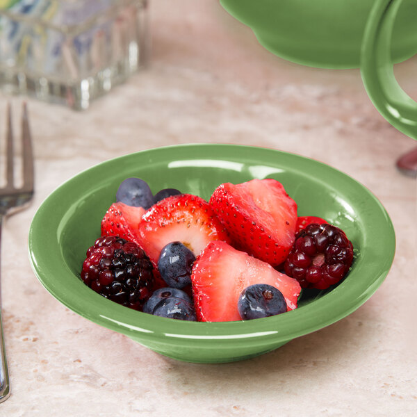 A Libbey Cantina sage porcelain fruit bowl filled with fruit on a table.