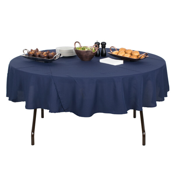 A Correll round folding table with mocha granite finish set with food on a blue tablecloth.