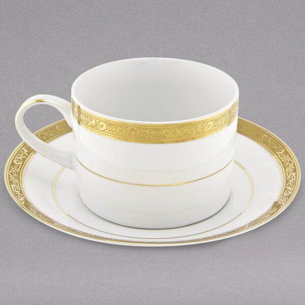 A 10 Strawberry Street Paradise white and gold porcelain cup and saucer with a gold rim.