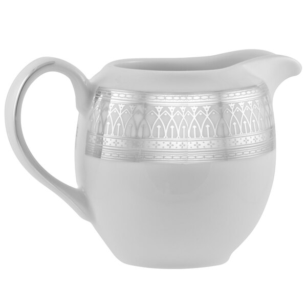 A white porcelain creamer with silver accents.