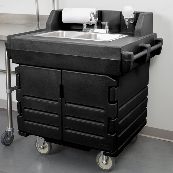 A black Cambro portable self-contained hand sink on wheels with a granite gray door.