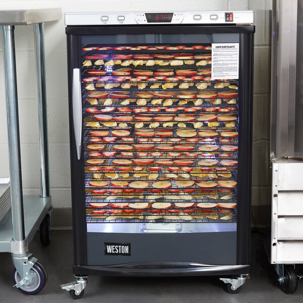 A Weston food dehydrator with racks of food in it.