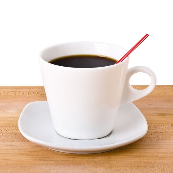 A white cup of coffee with a red straw in it.