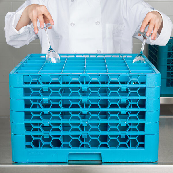 A chef holding a blue Carlisle glass rack with hexagons.