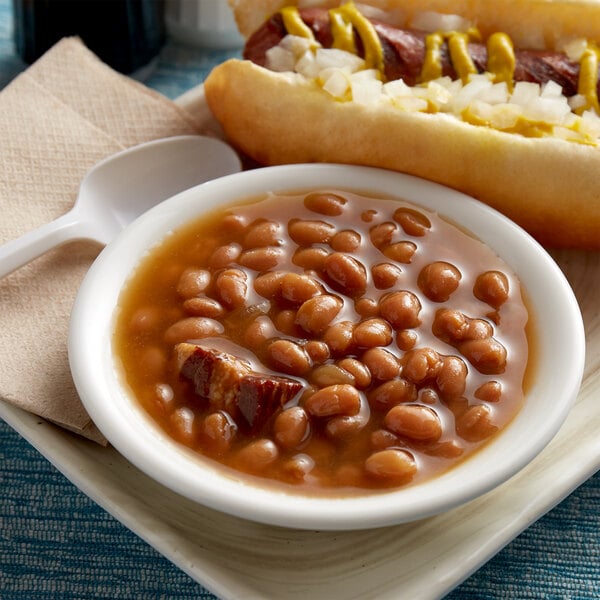 A bowl of Furmano's baked beans with a hot dog on a tray.