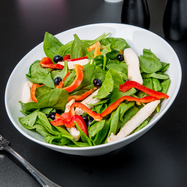 A Libbey white porcelain bowl filled with salad with chicken and peppers.