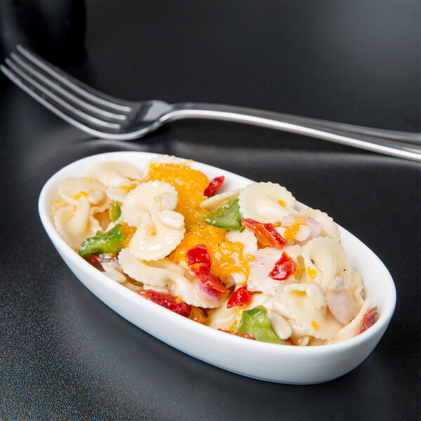 A Libbey white porcelain oval bowl filled with pasta and vegetables.