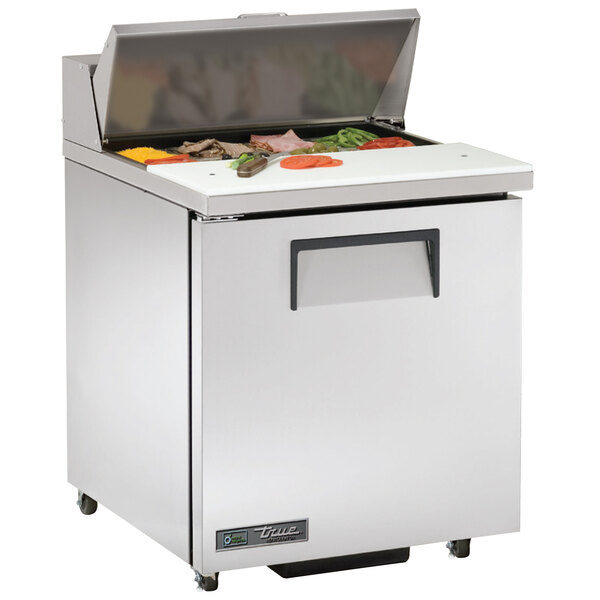 A True stainless steel refrigerated sandwich prep table with food on it.