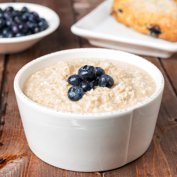 A Libbey Farmhouse ivory porcelain oatmeal bowl filled with oatmeal and blueberries.